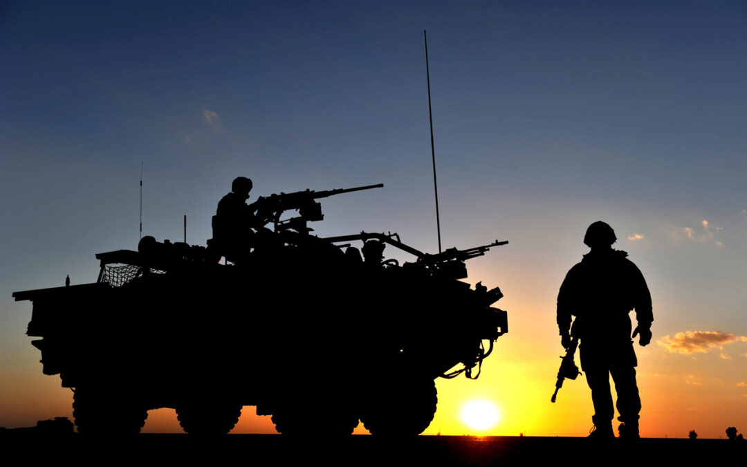 A Jackal Vehicle and Soldier Stand Guard at a Vehicle Checkpoint in Afghanistan